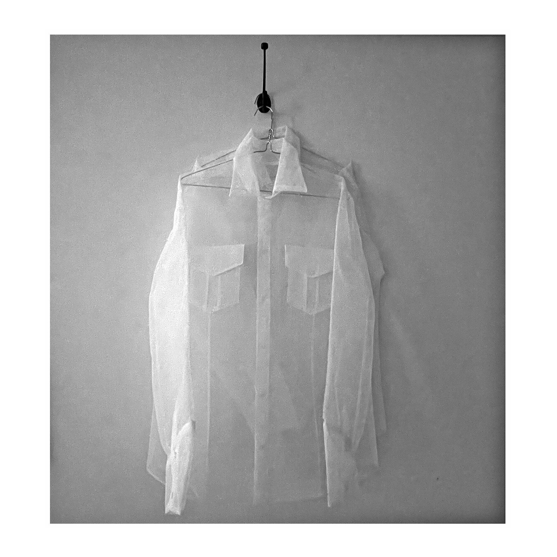 Christine Druitt Preston: Ghost Shirts, for two brothers (Maurice and Jack), 2022. Two Machine stitched tulle ghost shirts on metal hanger, on black coat hook. Size: Variable dimensions