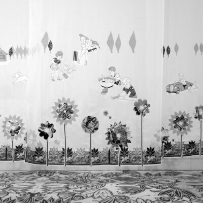 Christine Druitt Preston: Come and Play, 2022. Installation of 4 vertical panels topped with an inserted wooden slat with hanging wires attached. Sheer fabric, embroidery, appliqued lino block print. Size: 330 x 158 cm.